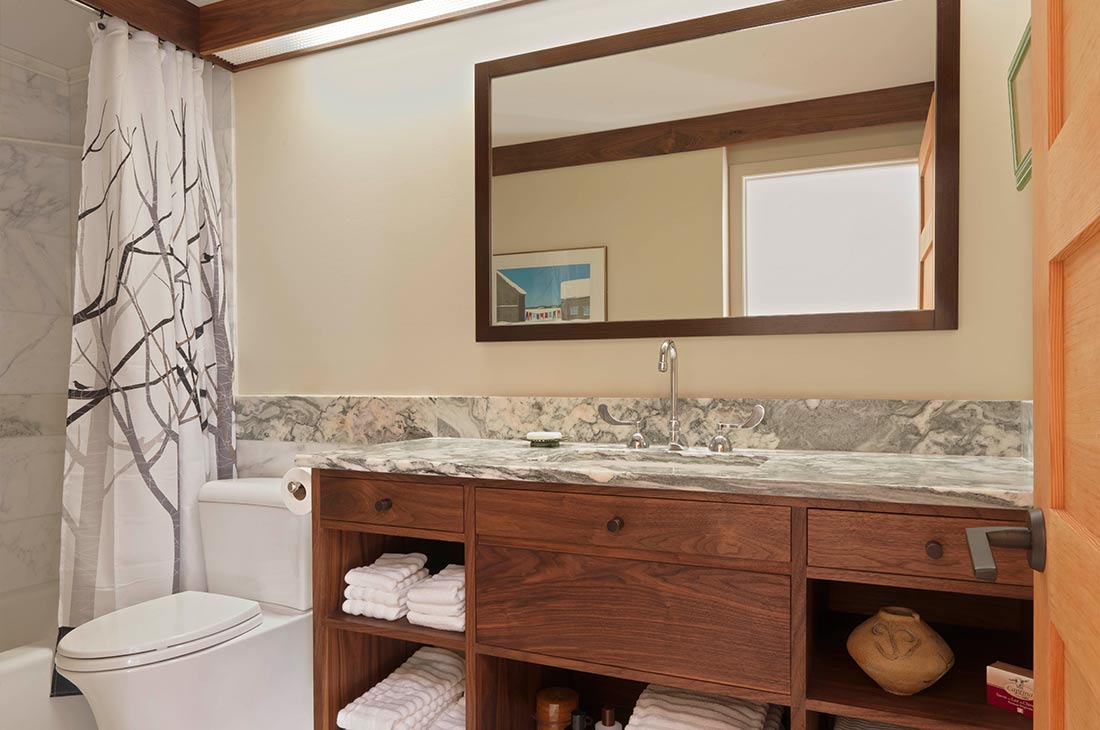 bathroom with marble countertop and large mirror