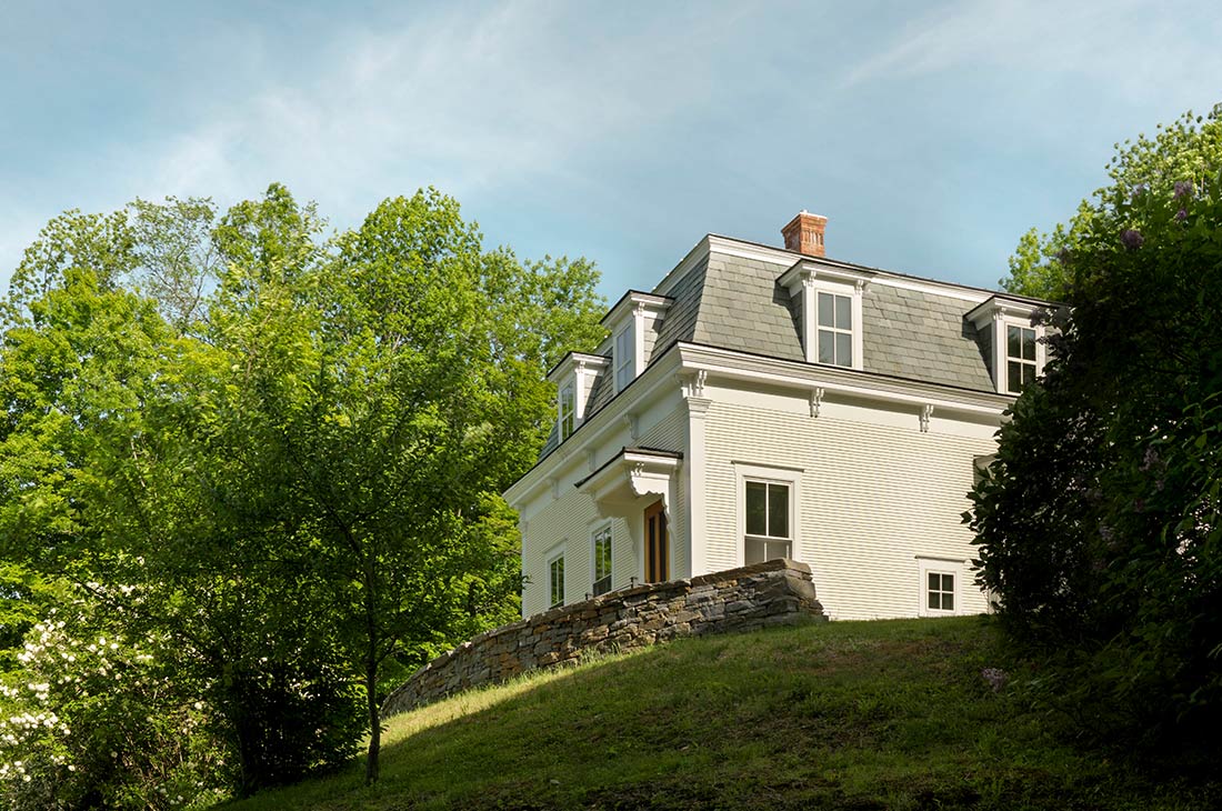 picture of exterior of them home, historical details and stone wall