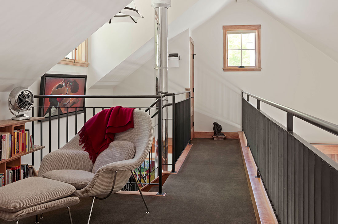 picture of the loft area, black railings and reading corner