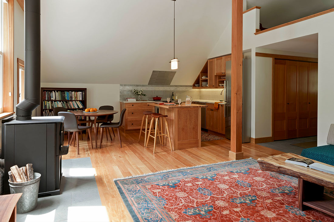 picture of the main living area with a woodstove and kitchen