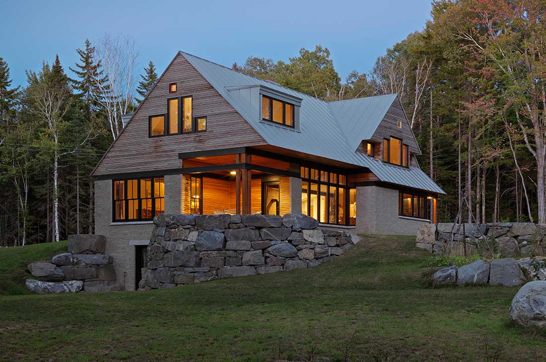 picture of the exterior with wooden siding and rock wall