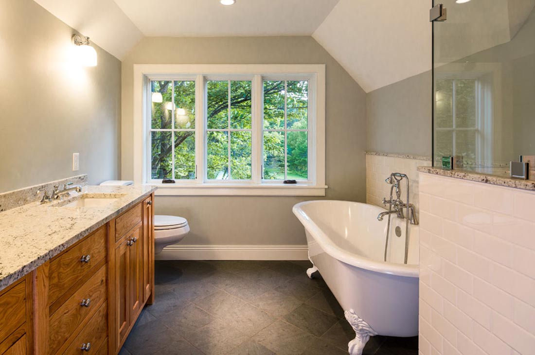 bathroom with clawfit tub and large window