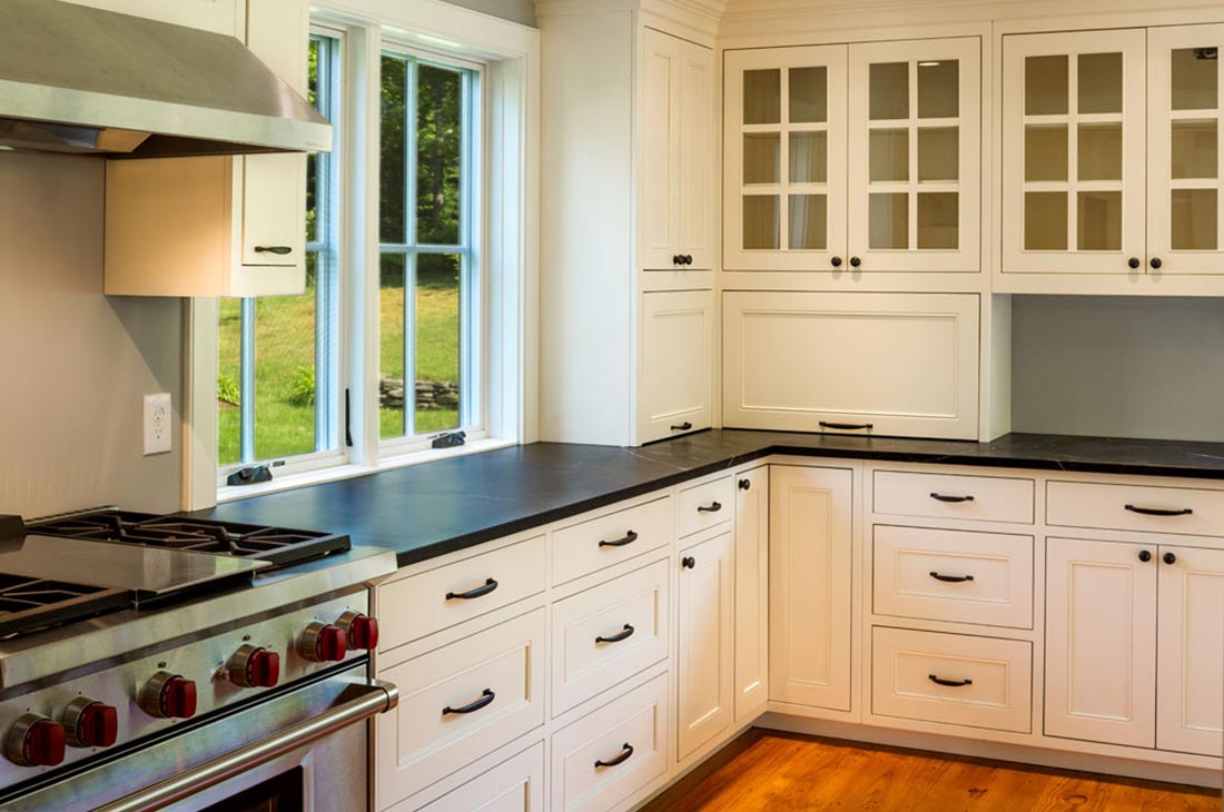 white kitchen with dark countertop and gas range