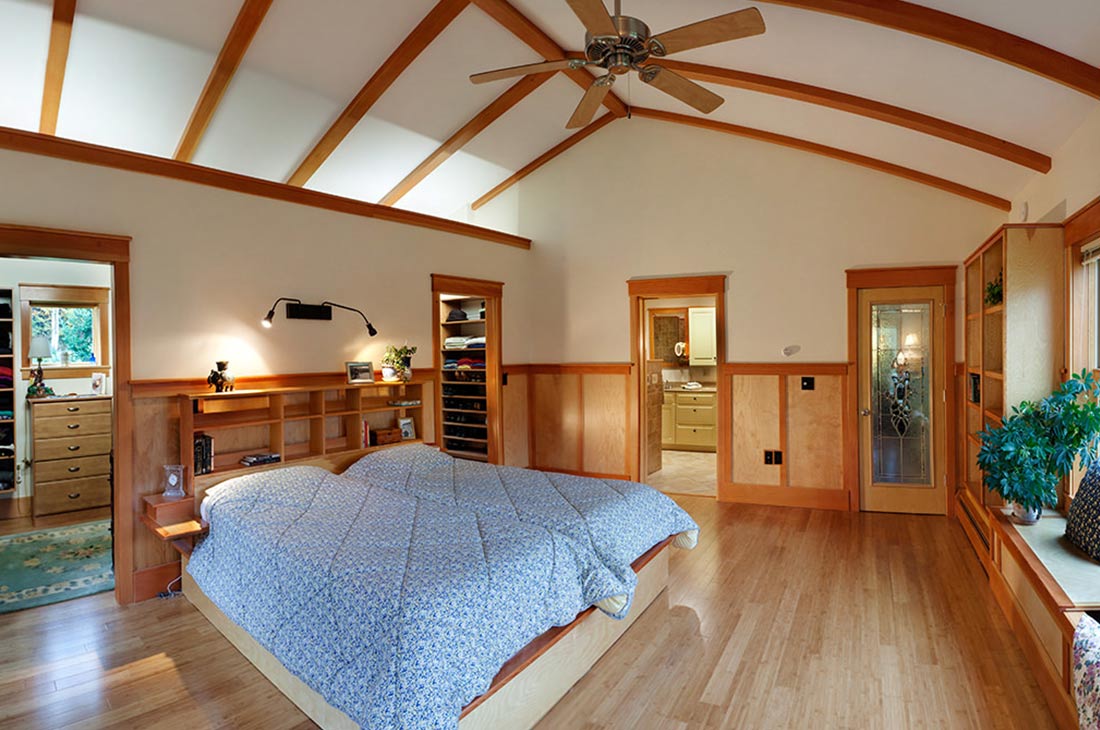 view of the bed and headboard looking into walk in closet