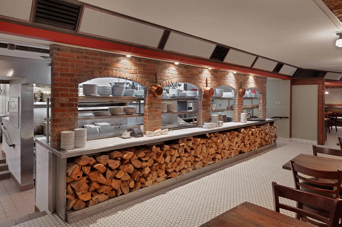 an open kitchen with arches and woodstack