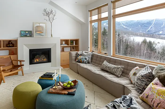 livingroom with fireplace and views of a ski resort through the window